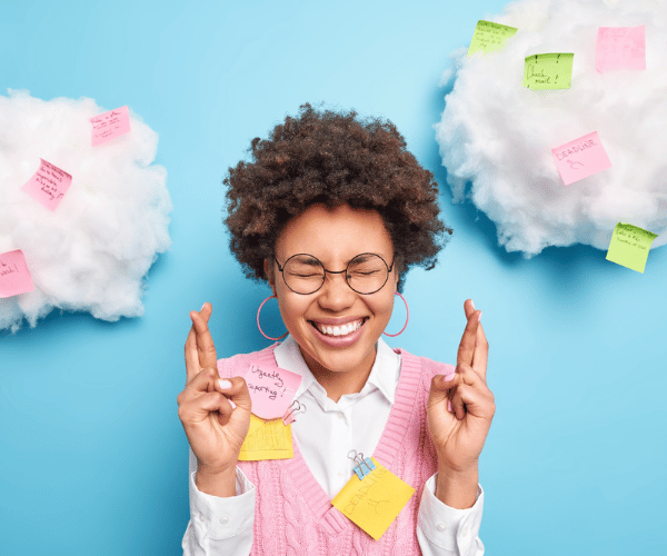 Femme croisant les doigts avec des nuages au dessus de sa tête